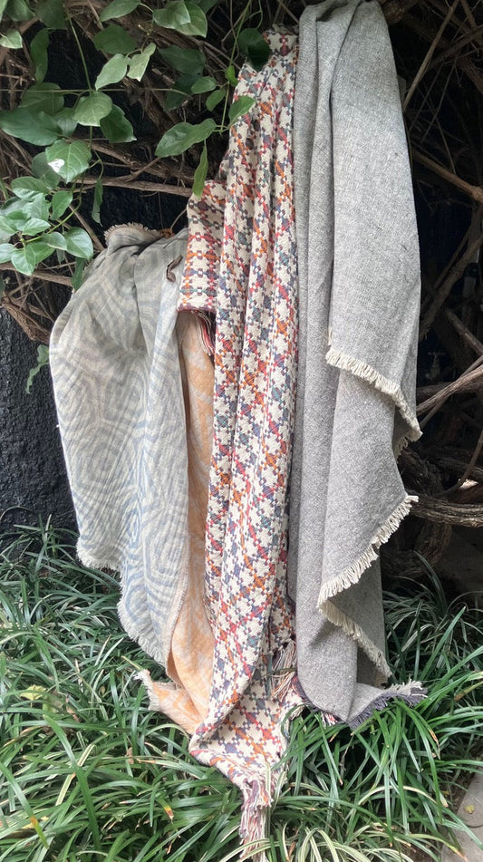 Patterned throws draped over a greenery