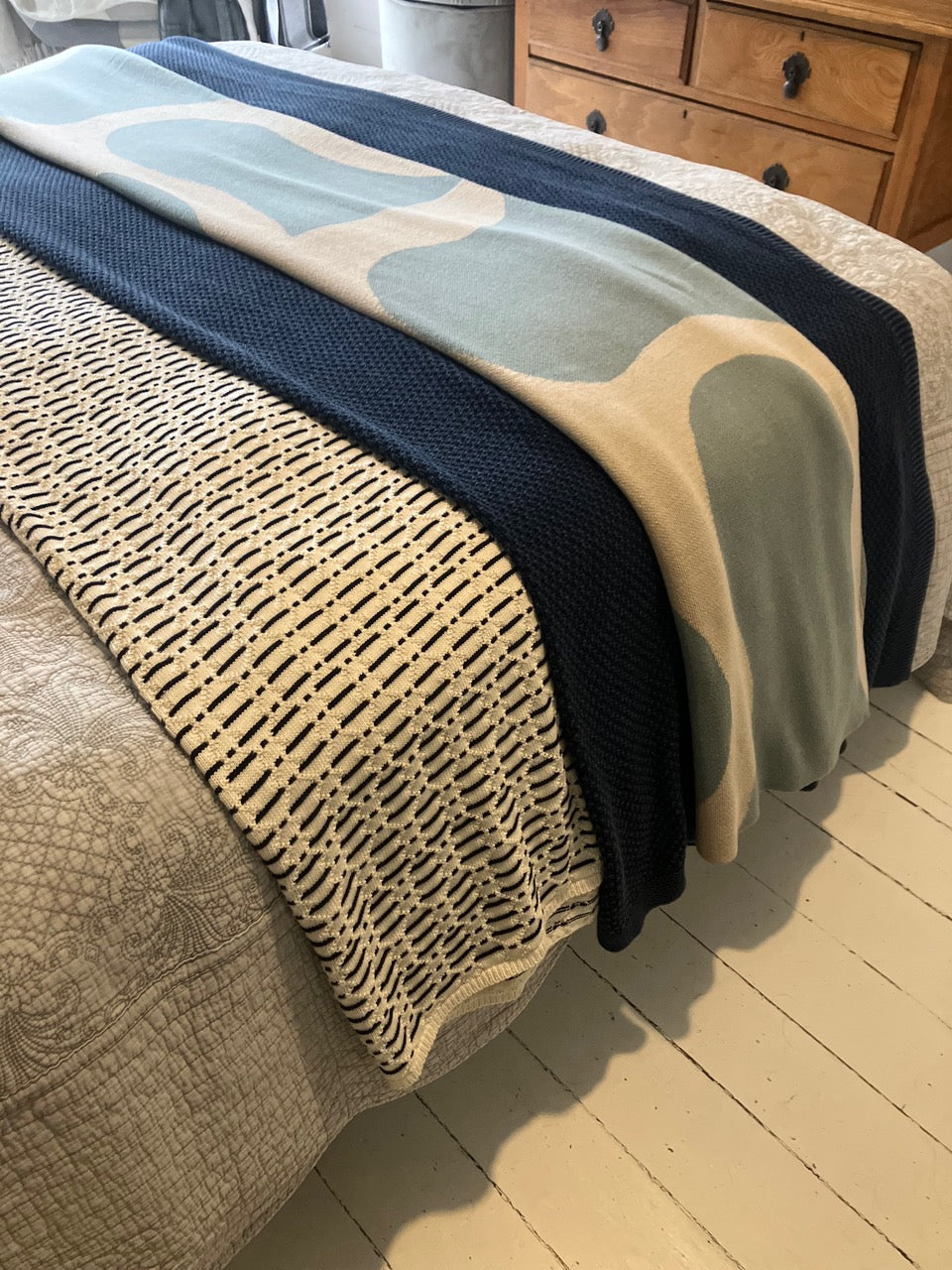Stack of folded throws on a bed